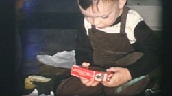 A cute two year old boy has fun opening all his cool birthday presents in front of his friends and family members in 1968.