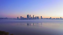 Aerial footage of fog blanketing the Swan River as the twilight breaks on the horizon behind the Perth City skyline in Western Australia.