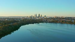 Aerial shot of Perth City skyline behind Lake Monger in Western Australia with the Mitchell Freeway in view.